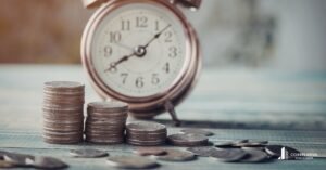 Foto Reloj y monedas en mesa